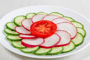Close-up of sliced cucumber, radish and tomato