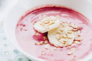 Close up of strawberry smoothie with bananas and oat flakes.