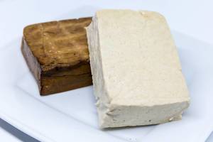 Close-up of tofu and smoked tofu on a white plate
