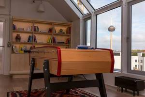 Close-up of wooden table soccer at WeWork coworking Area in Cologne, Germany, with view of the Colonius Tower