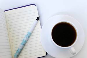 Close Up on The Coffee and Open Notebook With Pen