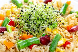 Close - up pasta with vegetables and micro onion greens