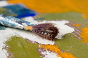 Close Up Photo of Artist Paint Brush on a Palette with different Colors
