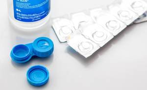 Close Up Photo of Contact Lenses Case Box with Moisturize Cleaner and Contact Lenses on Table