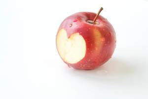 Close Up Photo of Fresh Apple with Heart Shaped Bite on White background