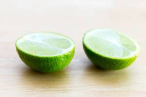 Close Up Photo of Halved Lime on Wooden Table