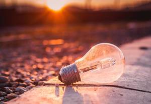 Close Up Photo of Lightbulb laying on the Ground with Sunset in the Background