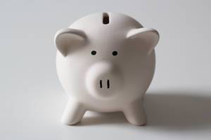 Close up photo of small white piggy bank on white background
