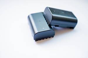 Close Up Photo of Two Black Camera Batteries on White Background