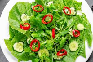 Close-up salad of fresh Romaine lettuce, cucumbers and chili peppers. Top view (Flip 2019)