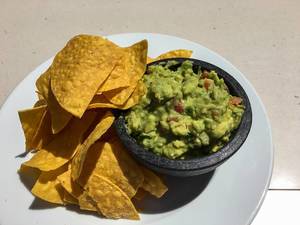 Close Up Top View Food Photo of Tortilla Chips with Avocado Dip