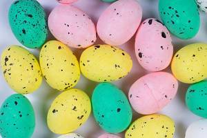 Close Up Top View Photo of Different Colored Easter Eggs on a White Table
