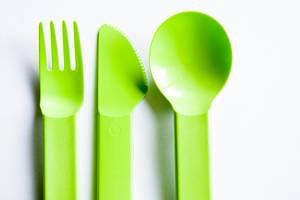 Close Up Top View Photo of Green Plastic Cutlery on White Background