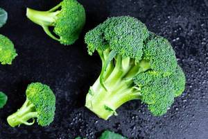 Close Up Top View Photo of Large Fresh Broccoli on Black Wet Background