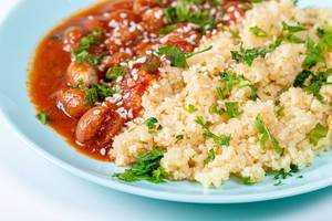 Closeup cereal couscous with spacely in tomato sauce and sesame seeds (Flip 2019)