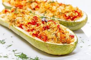 Closeup of baked zucchini halves with vegetables and couscous (Flip 2019)