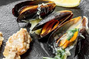Closeup of cooked mussels on black stone background (Flip 2019)