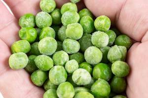 Closeup of Frozen Green Peas in the hand (Flip 2019)