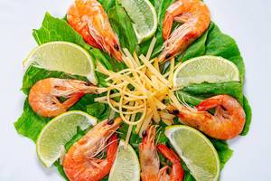 Closeup salad with romaine lettuce, shrimps, lime slices and grated cheese (Flip 2019)