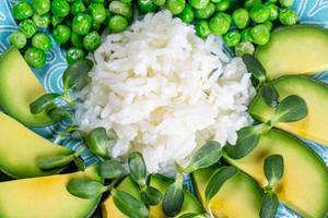 Closeup white rice with avocado, green peas and sunflower microgreen