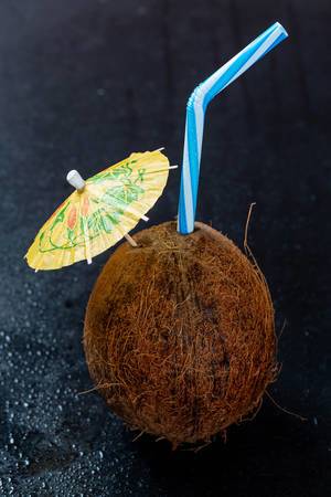 Coconut cocktail with an umbrella and a straw