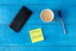 Coffe Break concept with cup of Coffee and Mobile Phone on the table