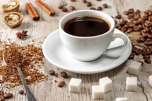 Coffee cup and beans on wooden table with spices, ground coffee and sugar cubes (Flip 2019)