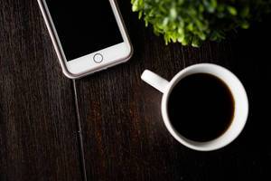 Coffee cup and phone on a wooden table (Flip 2019)