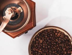 Coffee mill and cup with beans on white background