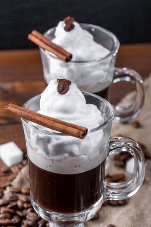 Coffee with whipped cream and cinnamon stic
