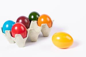 Colored Easter eggs in a box on white background
