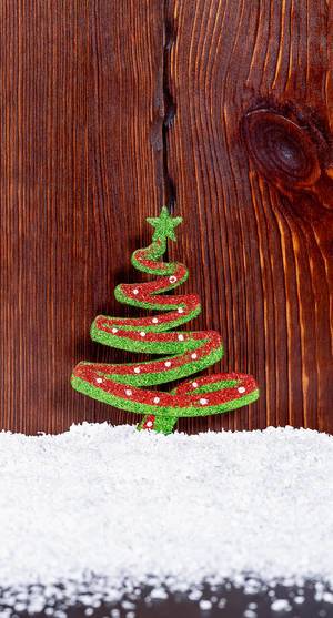 Colorful Christmas toy tree on the background of wooden boards and snow