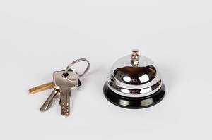 Concept of hotel reception with key ring and bell