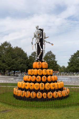 Concept of witch burning: skeletons as creepy Halloween decoration on a stake, pumpkins symbolize bonfire