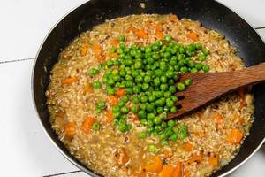 Cooked Integral Rice with Green Peas in the frying pan