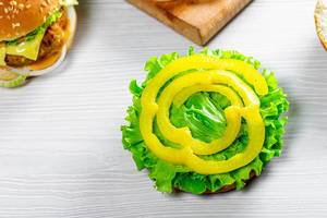 Cooking vegan burgers with fresh lettuce leaves and pieces of yellow pepper (Flip 2019)