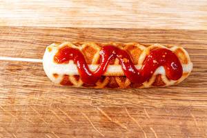 Corn dog with ketchup on wooden background (Flip 2020)
