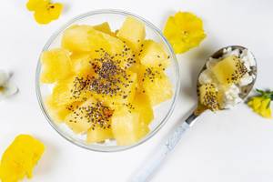 Cottage cheese with pineapple slices and Chia seeds on a white background, top view (Flip 2020)