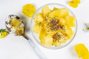Cottage cheese with pineapple slices and Chia seeds on a white background, top view