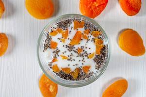 Cottage cheese with yogurt, Chia seeds and pieces of dried apricots. Top view (Flip 2019)