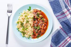 Couscous porridge with beans in tomato sauce, parsley and sesame seeds. Top view (Flip 2019)