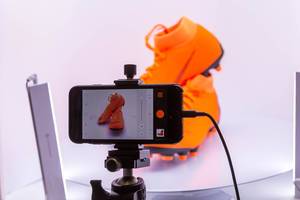 Creating product pictures of orange Nike football shoes with an Iphone on stative