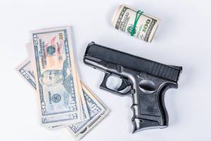Crimes concept, with guns and dollar bills on white background
