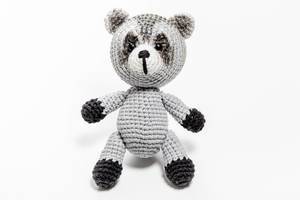 Crochet handmade raccoon toy on a white background
