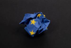 Crumbled paper in blue with stars as the European flag symbolising the critical situation for Europe