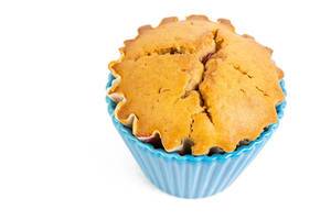 Cupcake-Muffin mit Vanille, in einem blauen Fröschen, isoliert vor weißem Hintergrund