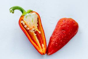 Cut red pepper halves on white background