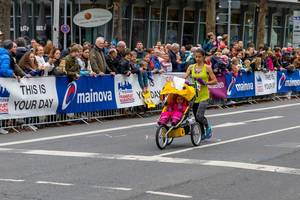 Dame beim Frankfurter Marathon als Teilnehmerin mit einem Kinderwagen und Kind