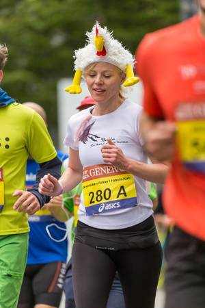 Dame mit Huhn Maskottchen auf dem Kopf beim Frankfurt Marathon - Hahn im Korb