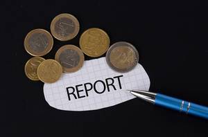Das Konzept vom Report: Report Text auf einem Blatt Papier mit einigen Münzen und einem blauen Stift im schwarzen Hintergrund